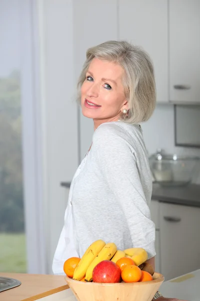 Старша жінка стоїть на кухні — стокове фото