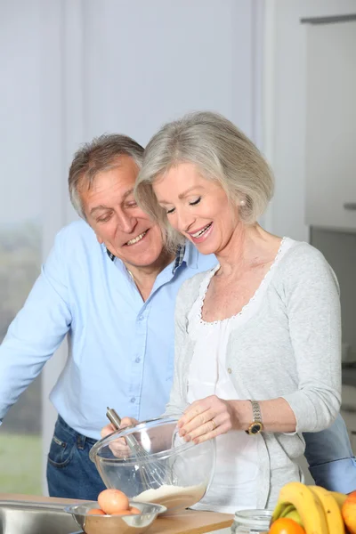 Senior couple in kitchen baking cake — Stock Photo, Image
