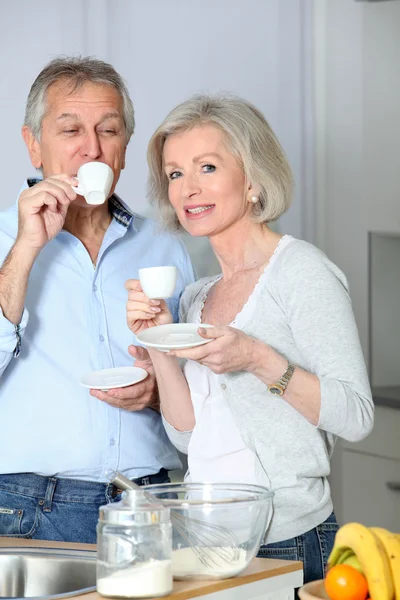 Senior koppel koffie houdend in keuken — Stockfoto