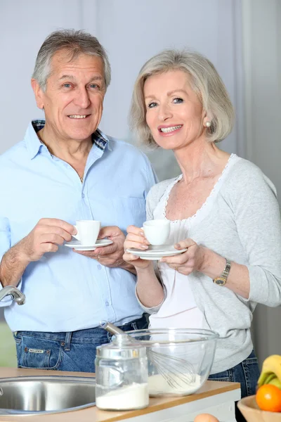 Senior koppel koffie houdend in keuken — Stockfoto