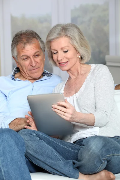 Senior couple surfing on internet with electronic tablet — Stock Photo, Image