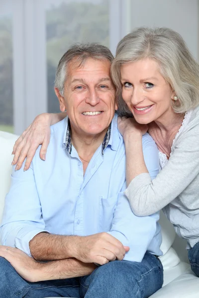 Portrait of happy senior couple sitting in sofa — Stock Photo, Image
