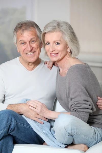 Portrait of happy senior couple sitting in sofa — Stock Photo, Image