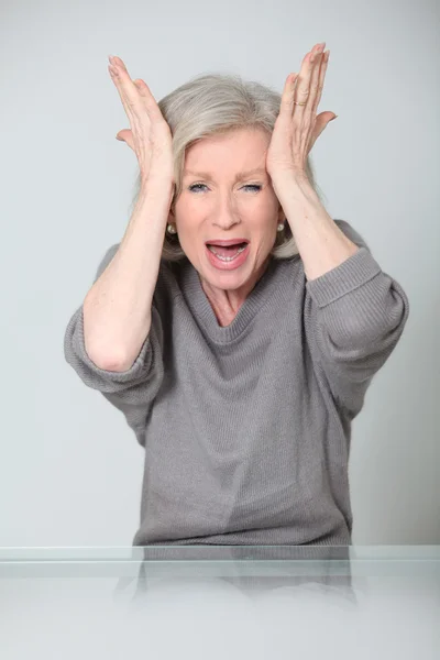 Closeup of senior woman with hands on head — Stock Photo, Image