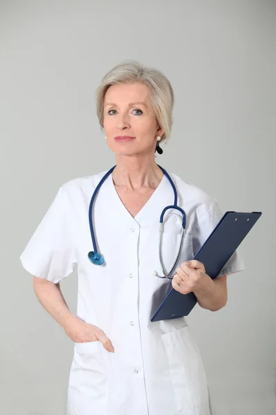 Close-up de enfermeira sênior em pé sobre fundo branco — Fotografia de Stock