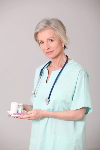 Primo piano di infermiera anziana in piedi su sfondo bianco — Foto Stock