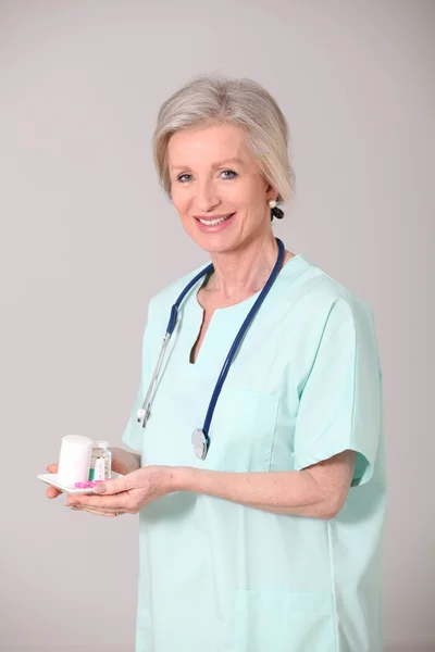 Primo piano di infermiera anziana in piedi su sfondo bianco — Foto Stock