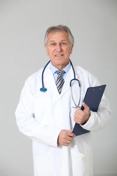 Médico sênior em pé sobre fundo branco — Fotografia de Stock