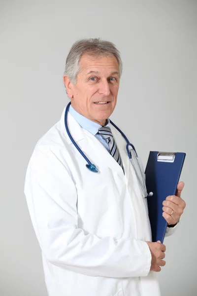 Médico senior de pie sobre fondo blanco — Foto de Stock