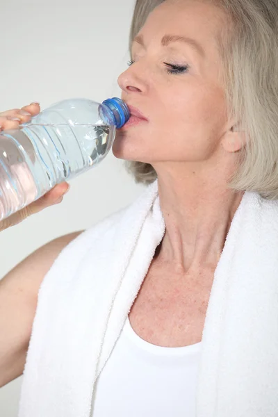 Πορτρέτο του ανώτερος γυναίκα με μπουκάλι νερό μετά την άσκηση — Φωτογραφία Αρχείου