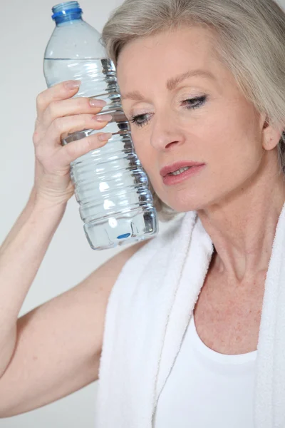 Портрет старшої жінки з пляшкою води після фізичних вправ — стокове фото