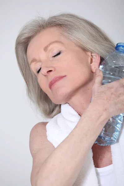 Portrét starší ženy s lahví vody po výkonu — Stock fotografie