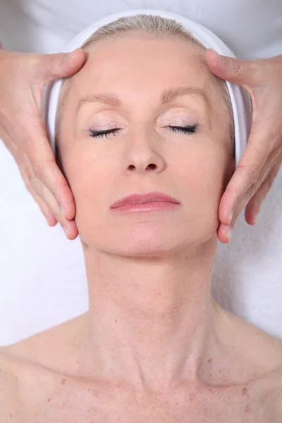 Fechar-se de mulher sênior com uma massagem facial — Fotografia de Stock