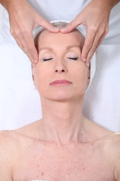 Primer plano de la mujer mayor teniendo un masaje facial — Foto de Stock