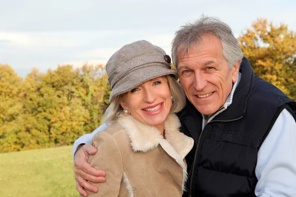 Lyckliga äldre par omfamnar varandra på landsbygden — Stockfoto