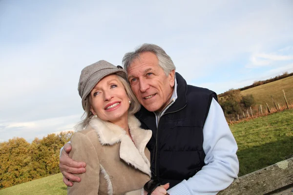 Feliz pareja de ancianos abrazándose en el campo — Foto de Stock