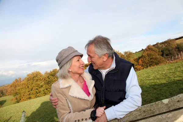 Glückliches Seniorenpaar umarmt sich auf dem Land — Stockfoto