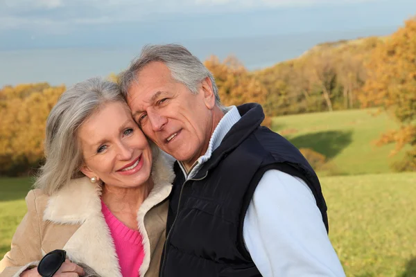 Glückliches Seniorenpaar umarmt sich auf dem Land — Stockfoto