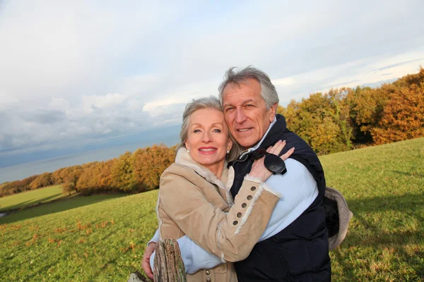 Счастливая пожилая пара обнимает друг друга в сельской местности — стоковое фото