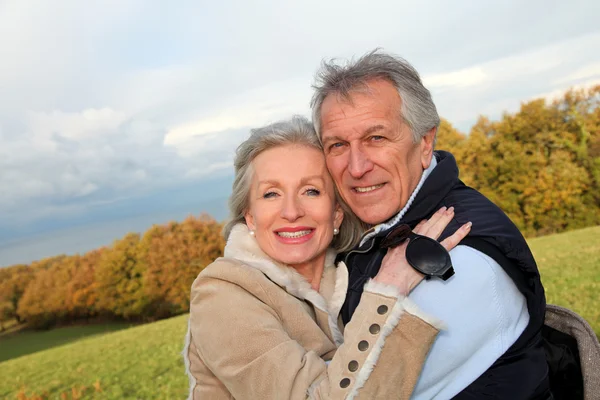 Felice coppia di anziani che si abbracciano in campagna — Foto Stock