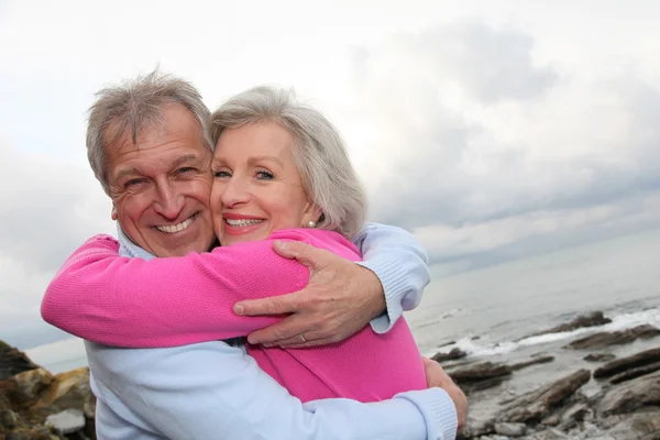 Glückliches älteres Paar, das sich am Meer umarmt — Stockfoto