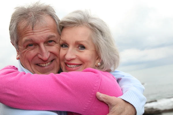 Happy senior couple embracing each other by the sea — Stock Photo, Image