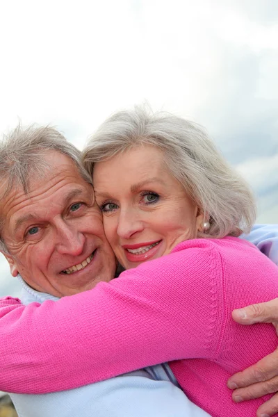 Feliz pareja de ancianos abrazándose en el mar — Foto de Stock