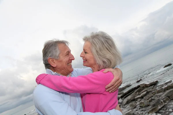 Deniz kenarında birbirlerine kucaklayan kıdemli mutlu çift — Stok fotoğraf