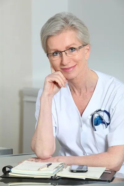 Портрет улыбающейся зрелой медсестры в офисе — стоковое фото