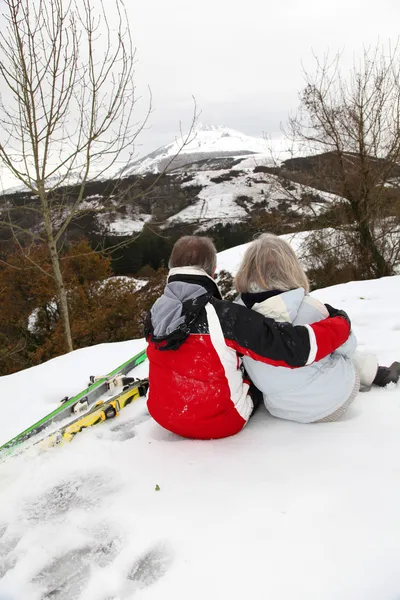 Starší pár na lyžařských resortlooking na horu — Stock fotografie