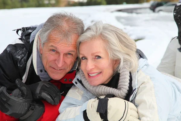 Starší pár baví v lyžařském středisku — Stock fotografie