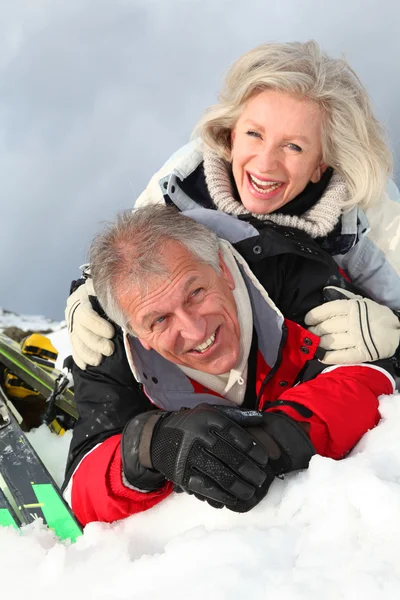 Старшая пара веселится на горнолыжном курорте — стоковое фото