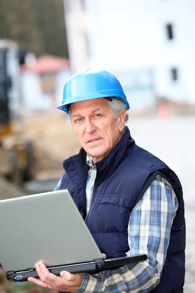 Architect with drawing on construction site — Stock Photo, Image