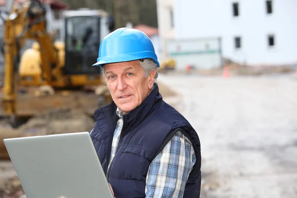 Architect with drawing on construction site — Stock Photo, Image