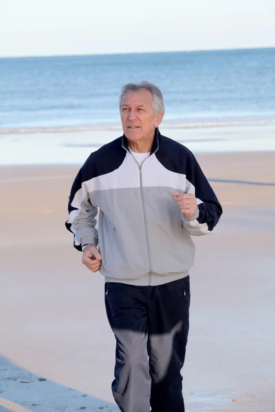 在海滩上慢跑的高级男人 — 图库照片