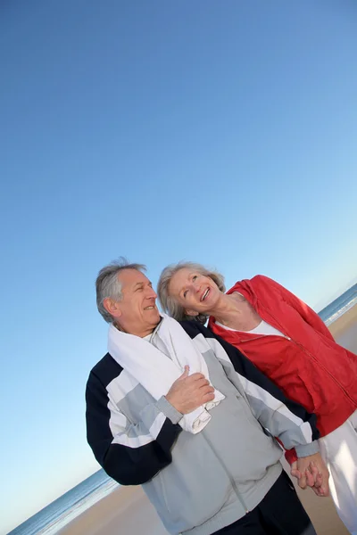Senior koppel trainen door de zee — Stockfoto