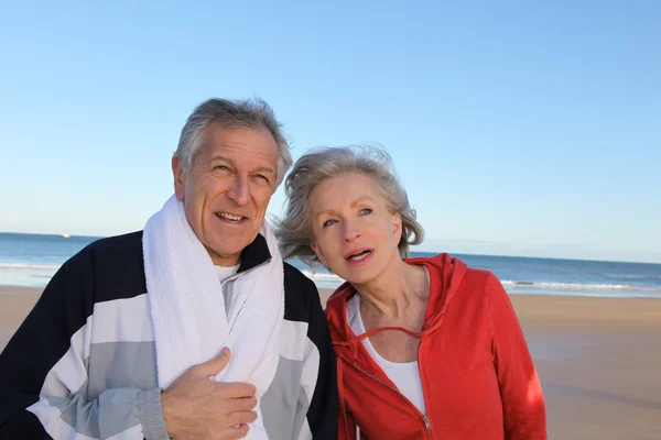 Starší pár, cvičení u moře — Stock fotografie