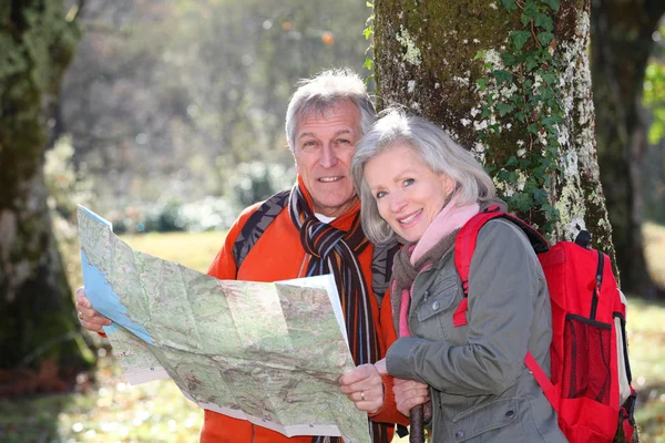 Äldre par med karta på en vandring dag — Stockfoto