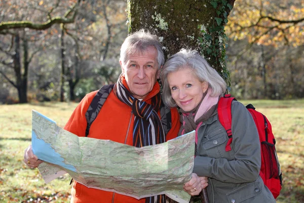 高级夫妇与上一天的徒步旅行地图 — 图库照片