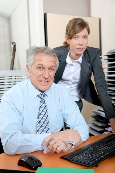 Старший бізнесмен з молодою жінкою в офісі — стокове фото