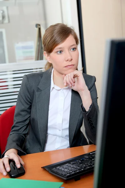 Jonge vrouw in kantoor achter computer — Stockfoto