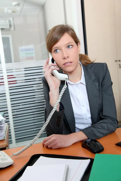 Młoda kobieta w biurze rozmawia przez telefon — Zdjęcie stockowe