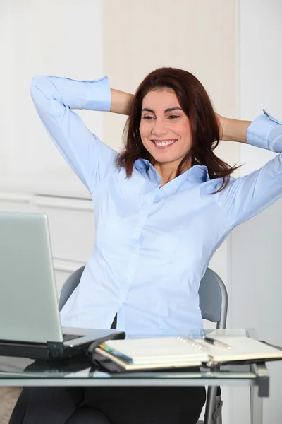 Бізнес-леді з розтягнутими руками в офісі — стокове фото