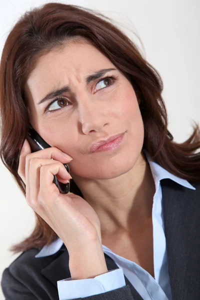 Mujer de negocios en el teléfono con aspecto preocupado — Foto de Stock