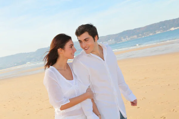 Porträt eines schönen Paares, das am Strand spaziert — Stockfoto