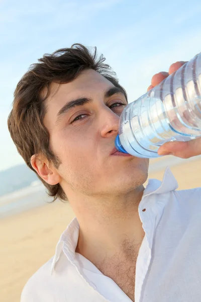 Closeup člověka pitné vody z láhve — Stock fotografie