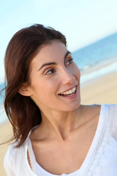 Портрет красивой улыбающейся женщины на пляже — стоковое фото
