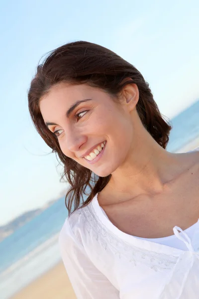 Portret van mooie lachende vrouw op het strand — Stockfoto