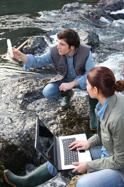 Biologistes testant l'eau de rivière naturelle — Photo