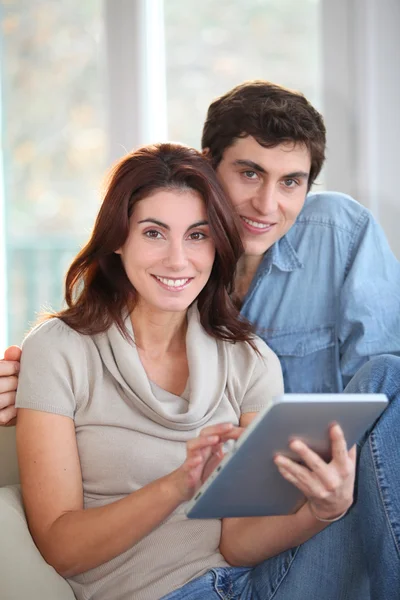 Mladý pár, pomocí elektronické počítače tablet doma — Stock fotografie